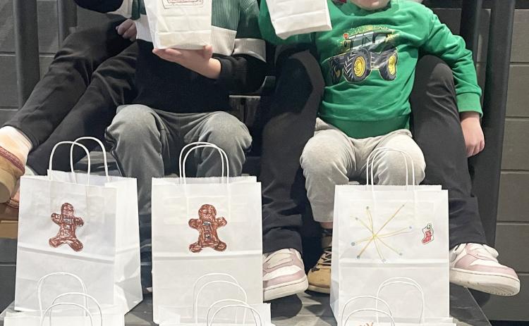 Pictured are Caroline, Lily, Logan and Connor, the spirited children of Tyler and Angela McLaren, display their handiwork after decorating gift bags for homebound Gladwin County residents. They are the grandchildren of Tina and Mike Haines, Kim and Pat Savage, and Mark and Amy Baker, all proud Beaverton residents.