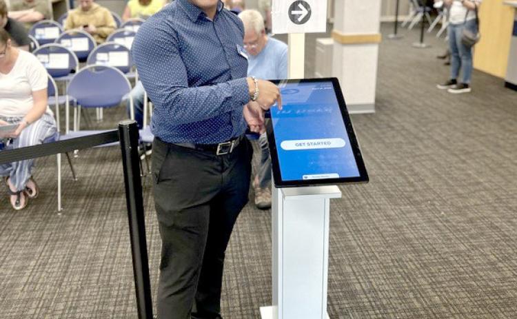 Xavier Henderson, branch manager of the Portage office, smiles for a photo at the check-in and booking station.