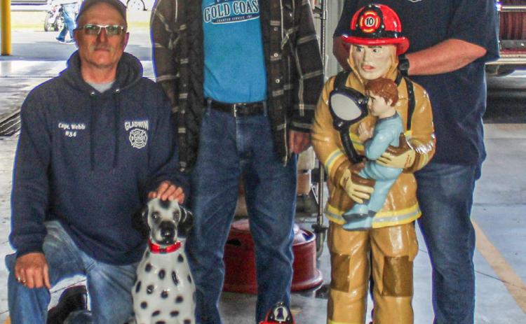 Pictured is Bill Webb (at left) and Scott Grice (at right) Julius Sinischo (at center) with the statues he restored for the Gladwin Rural Urban Fire Department.