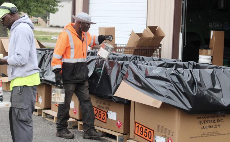 Workers sort out containers and dispose of them appropriately Saturday during Gladwin County Hazardous Waste Day at the Department of Public Works.