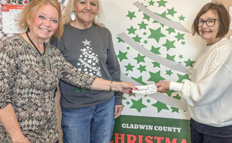 Jan Hudson (at left) presents a check to Christmas Kindness office girls, Brenda Povey (center) and Carolyn McNamara (at right).