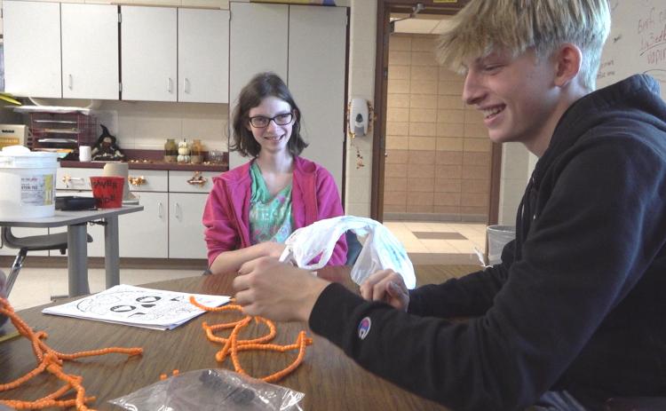 BJSHS Sophomore Maya VanSickle and her Links partner, senior George Killian, share a laugh while they work with Halloween decorations.