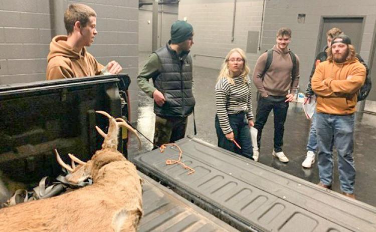 Northern Michigan University students examine a fake deer carcass loaded in the back of a hunter’s truck. Students in the university’s Conservation Law Enforcement program investigate several mock crime scenes to learn how to investigate environmental crimes. JEREMY SERGEY