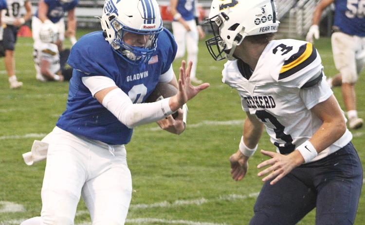 Gladwin’s Bronson Bigham wards off a would-be Shepherd tackler with a stiff arm. The junior scored two touchdowns and passed for a two-point conversion in Friday’s Homecoming victory.