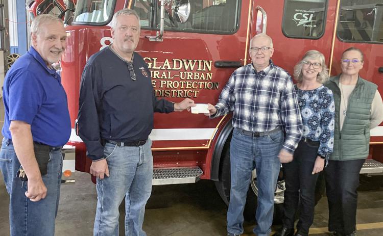 Pastor David Sprang and John Caffrey of the Gladwin Rural Urban Fire Department present a check for $1,000 to Kevin Brott, Lanette Morgan and Candace Pennell of the New Dawn Shelter. The funds for the donation were raised at the department’s golf outing in August.