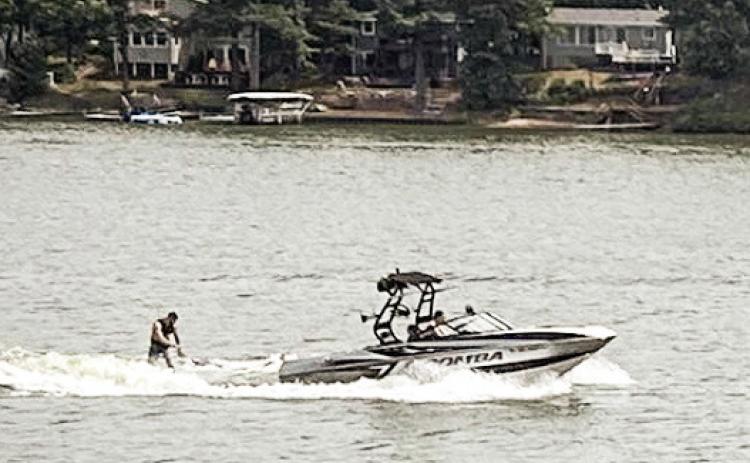 A wake boat tugging a wakeboarder cuts across Brooks Lake on a recent weekend afternoon. EMILIO PEREZ IBARGUEN/BRIDGE MICHIGAN