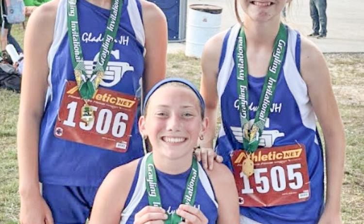 Chloe Johnson, Vada Povey, and Izzy Hurst with their medals from the Grayling Invitational.