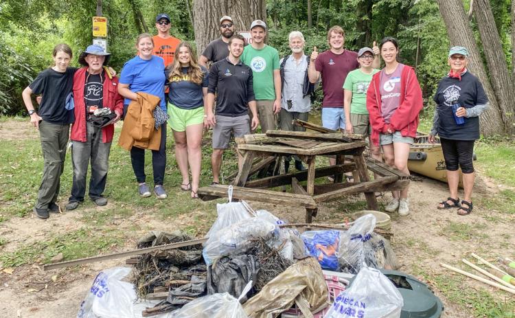 The Cedar River Cleanup volunteer group with the trash they retrieved from the river. PHOTO PROVIDED BY TRISTAN HEWITT