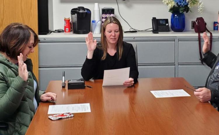 Trustees Jane Zdrojewski (at left) and Mike Jankoviak (at right) are sworn in by Fassett.