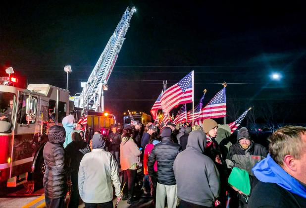 The Bangor Township Fire Department had a ladder truck waving the American Flag over the North Union overpass near Bay City on Thursday night (April 6). The overpass was closed to traffic during this time. Inset photo, U.S. Army Specialist Braden Peltier. PHOTO PROVIDED BY WHITNEY ALBERTSON