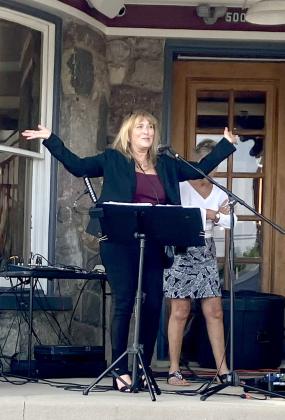 Char Stone House owner Sheryl Sacry welcomes the crowd and brings on the band Thursday at the new restaurant’s first event.