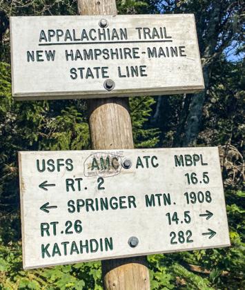 Loren McLaughlin is pictured hiking a tough section of the Appalachian Trail near Newry, Maine. Inset photo is the border sign between New Hampshire and Maine.