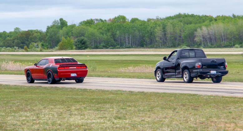 Zach Gradowski (left) races his Dodge Challenger during the Thunder on the Strip drag race event on Saturday, May 20 at the Gladwin Zettel Memorial Airport.