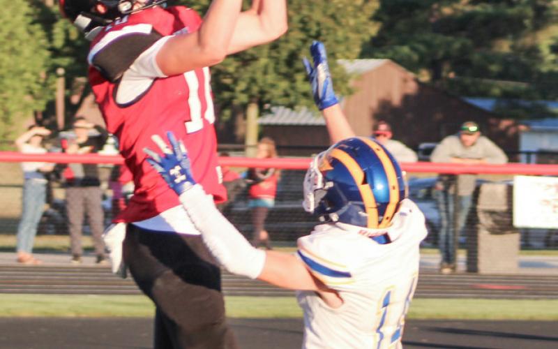 Ian Roberts goes up and over an Evart defensive back to catch a touchdown pass from Landon Love in the first half of Friday’s victory at Beaverton.