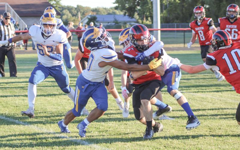 Beaverton running back Karter Offenbecker fights to break away from two Evart tacklers during Friday night’s season-opening victory.