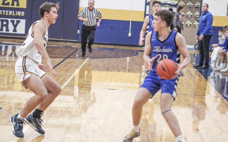 Gladwin’s Brody Verellen looks toward the paint for an open teammate during Friday night’s district final battle with Standish.