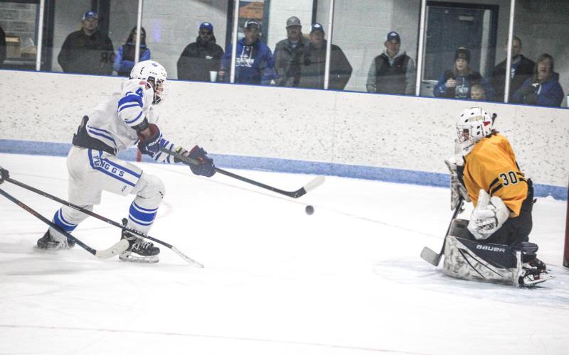 Ike Wheeler shoots and scores the game’s first goal Saturday as the Gladwin hockey team racked up its fifth victory in a row by beating Cadillac.