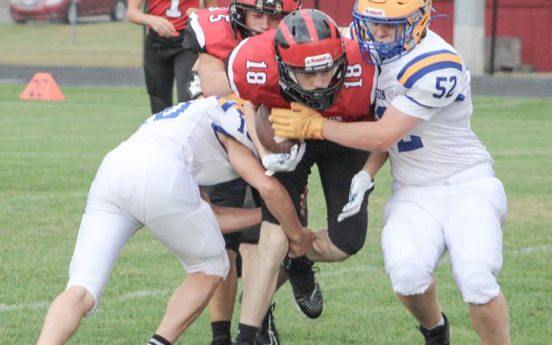 Beaverton’s Mitchell Malmo tries to split two Harrison defenders during Thursday’s junior varsity victory for the Beavers.