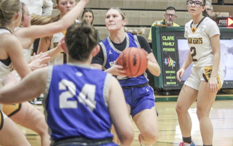 Gladwin’s Liz Winchester eyes the bucket as she runs into a crowd during Monday night’s loss to Ogemaw Heights.