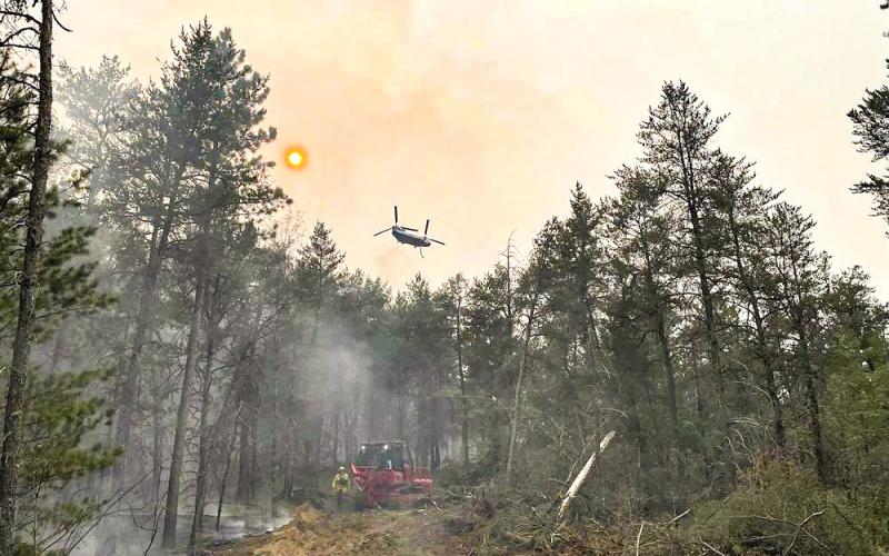 This image provided by the The Michigan Department of Natural Resources shows emergency personnel, aircraft and heavy equipment being used to suppress the wildfire near Grayling, MI, June 3, 2023. THE MICHIGAN DEPARTMENT OF NATURAL RESOURCES VIA AP
