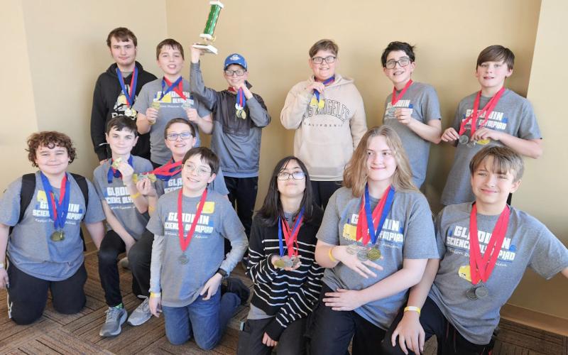The team posing with their second place trophy after a long day of competing.