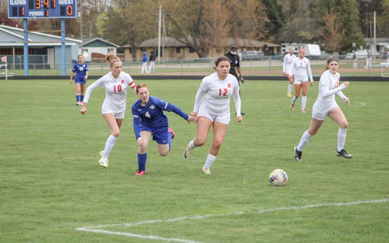 Gladwin’s Isabella Roman chases the ball toward the Beaverton net with Charity Danielak, Isabelle Dodman and Blaire Orton in hot pursuit during Wednesday’s game.