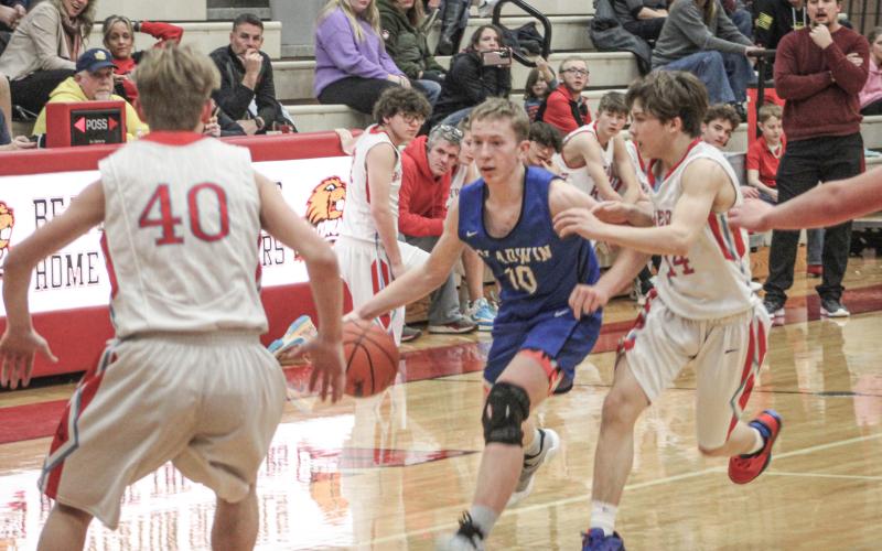 Gladwin’s Brayden Randle brings the ball up the floor against Beaverton defenders Riley Bock (left) and Trenton Kanyo during the Flying G’s junior varsity victory Thursday night.