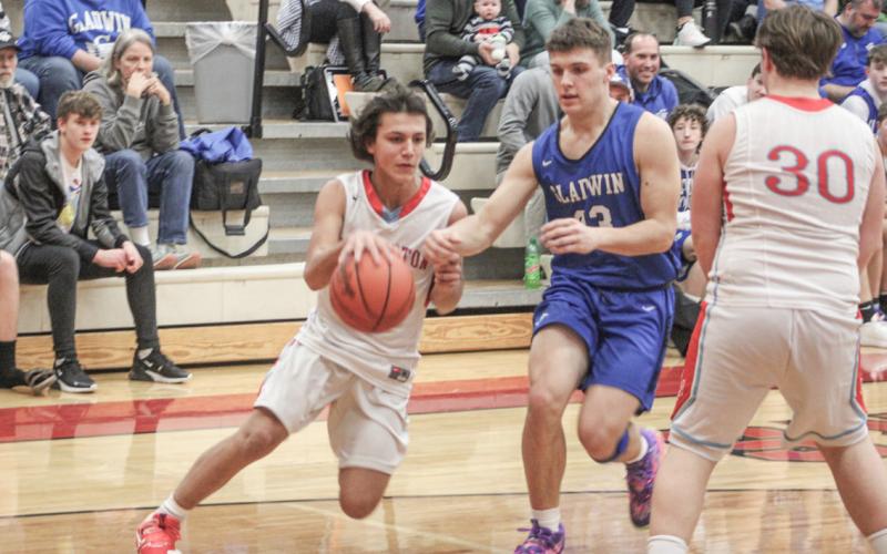 Beaverton’s Sean Barta tries to turn the corner on Gladwin defender Colton Pfenninger during Thursday night’s junior varsity battle between the rivals.