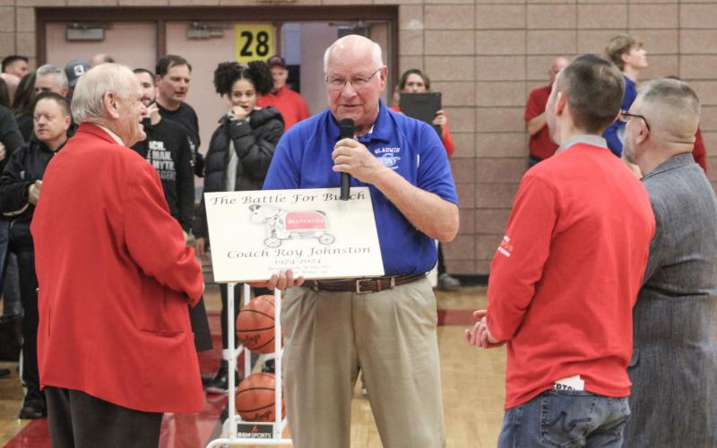 Gladwin’s Terry Brokoff presents Beaverton coach Roy Johnston with a placard commemorating the 100th time Johnston led the Beavers into the “Battle for Butch” prior to Friday night’s game.
