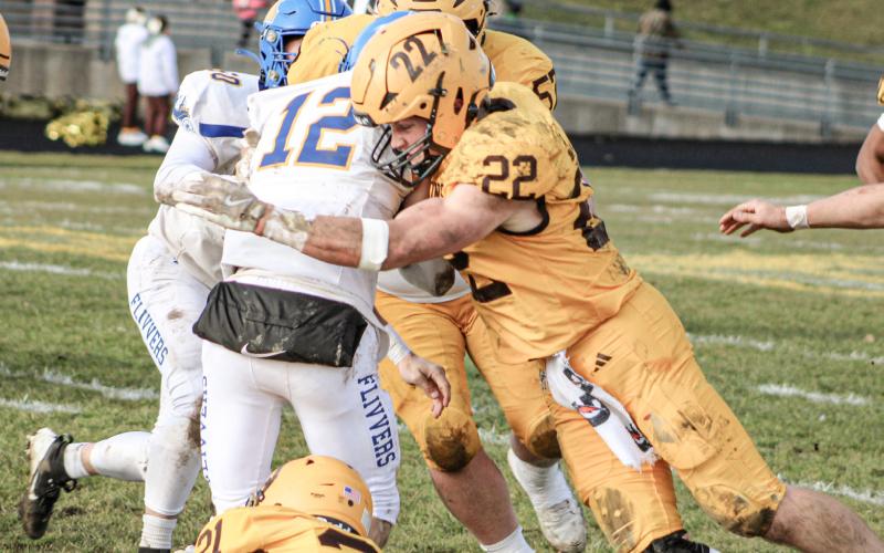 Ogemaw Heights’ Connor Lambert makes another big hit on Kingston quarterback Jack Kriegl during the Falcons victory in the second round of the playoffs Saturday.