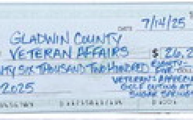 Volunteers for the golf outing are pictured at the ticket tables. Inset, at right, the check presented to Gladwin County Veteran’s Affairs.