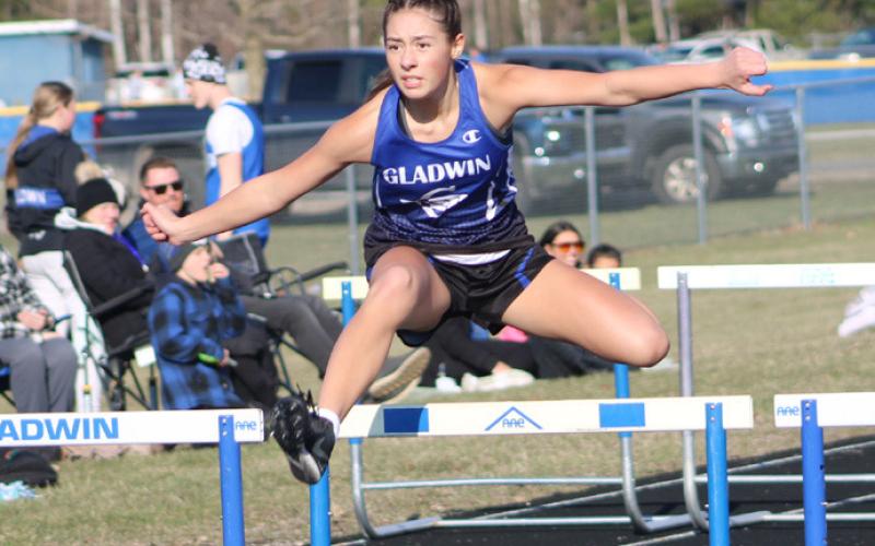Gladwin’s Elizabeth Huisjen goes up and over on her way to a victory in the 100 hurdles during last Wednesday’s meet.