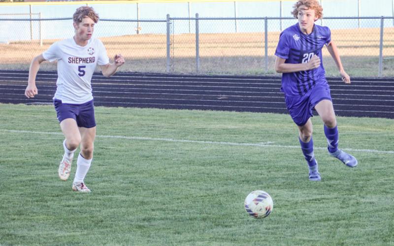 George Whittaker looks toward the front of the net as he closes in on the ball during last week’s district tournament game.