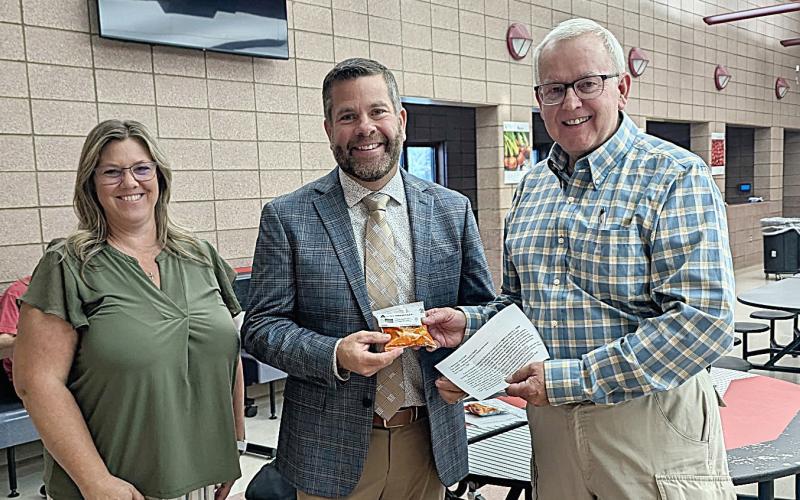 At Beaverton Schools staff member, Renee Inscho; and Elementary Principal, Josh Pahl, are presented snack appreciation bags by MARSP Gladwin Chapter president, Kevin Brott.