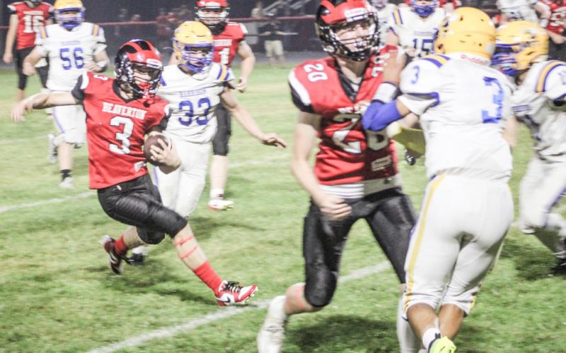 Beaverton’s Kamdyn Avila dodges would-be Harrison tacklers during Friday night’s Homecoming game.