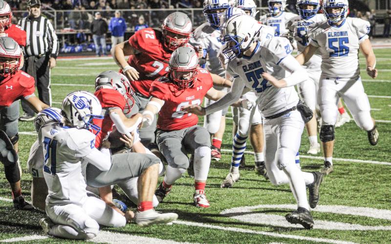 Gladwin’s Talon Goodwin finishes off a gang tackle with Jacob Pahl closing in during the first quarter of Friday night’s 35-0 loss at Frankenmuth in the third round of the Division 5 playoffs.