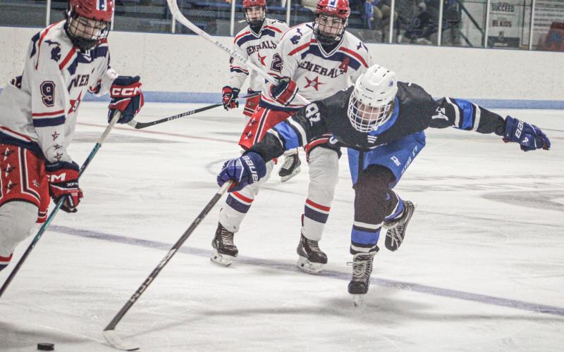 Gladwin’s George Whittaker stretches out to try for a poke check during Saturday’s 6-5 victory over the visiting Genesee Generals.