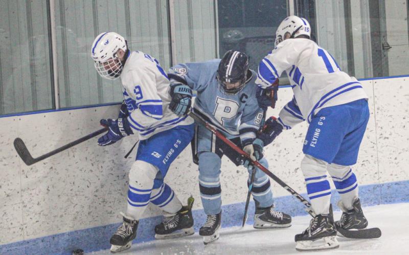 Gladwin’s Jeff Zeitz and Jacob Zeitz battle along the boards behind the net during Saturday’s loss to visiting Petoskey.