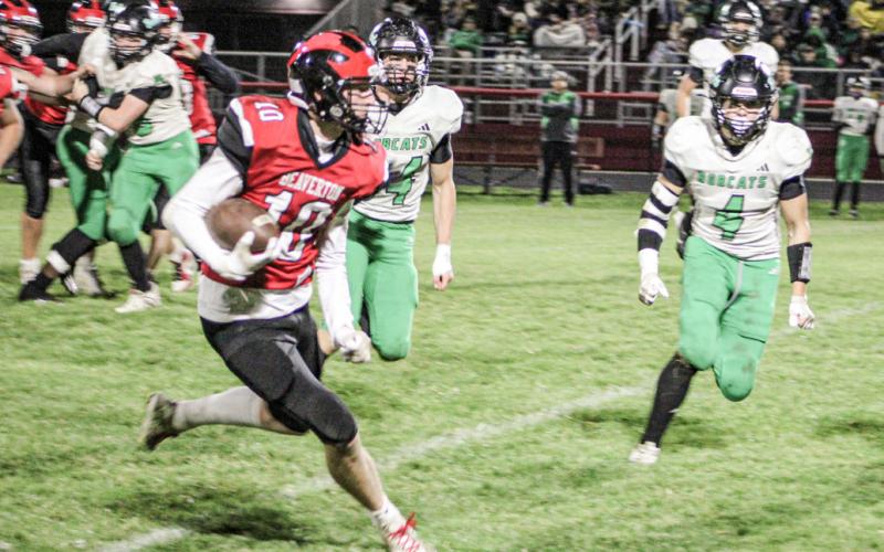 Beaverton’s Ian Roberts runs away from the Houghton Lake defense during Friday night’s season-ending victory.
