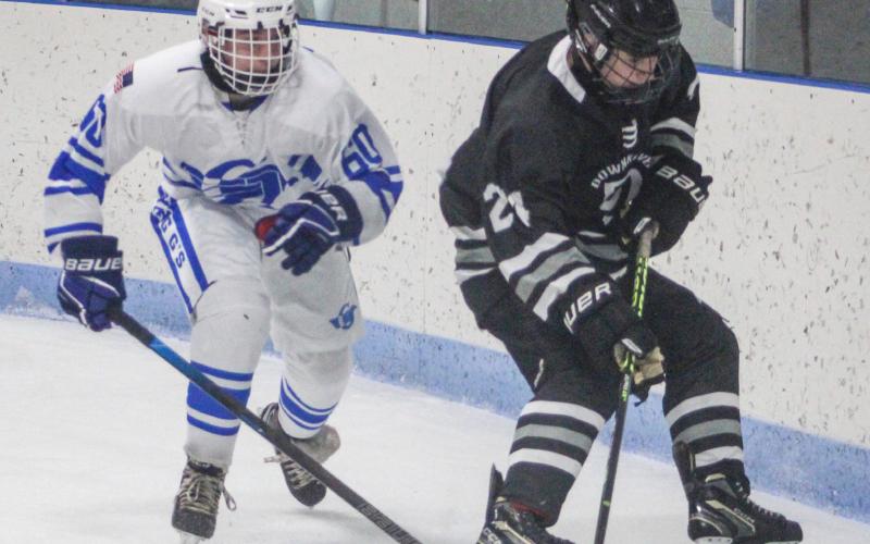 Gladwin’s Christian Burgess zeroes in on a Downriver United defenseman behind the net during the Flying G’s victory last month.