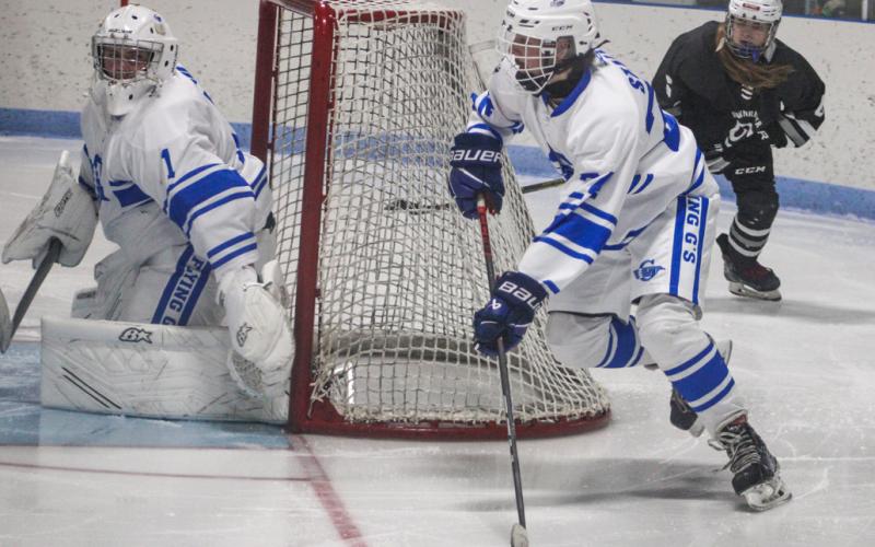 Gladwin’s Gunner Staley heads past goalie Trenton Reid and out of danger during the Flying G’s victory over Downriver United last month.