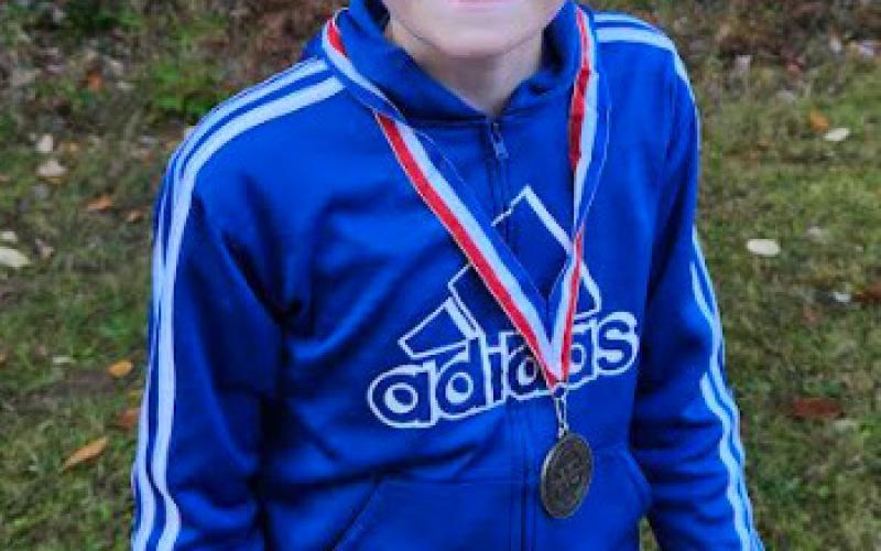 Intermediate runner Kolbe Edick with his medal after the race at Cedar Bend.