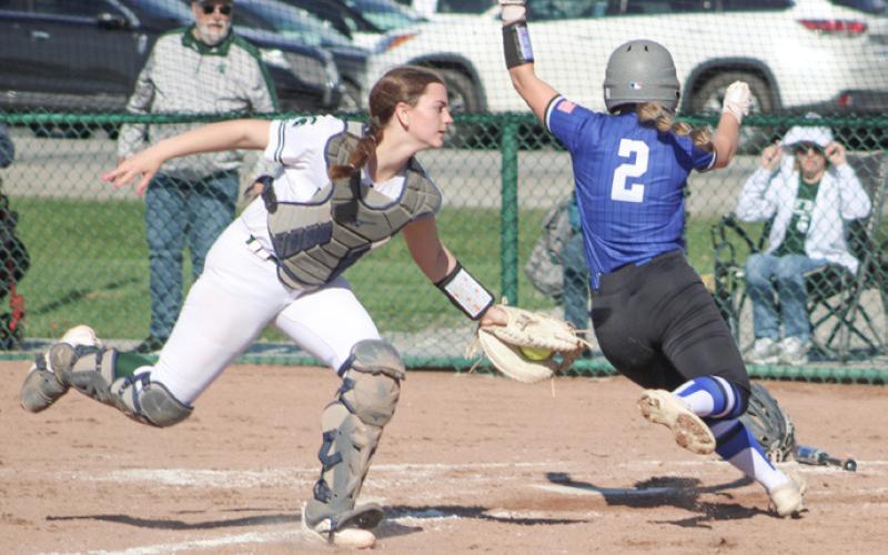 At left, Gladwin’s Addison Tyslicki is tagged out at the plate during the first game of Friday’s doubleheader at Pinconning. At right, Gladwin relief pitcher Alexis Farrow fires a strike during the first game of Friday’s doubleheader at Pinconning.