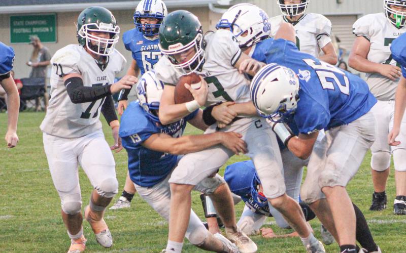Gladwin’s Leo Orvis and Hunter Wooster wrap up Clare ball-carrier Dalton Kruskamp during Thursday night’s junior varsity contest.