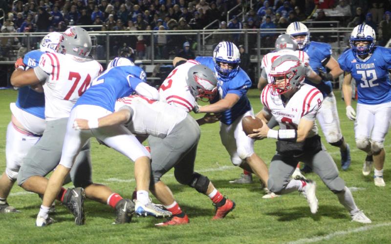 Gladwin’s defense tries to corral Frankenmuth quarterback Jack Rich during Friday night’s loss in the regular season finale.