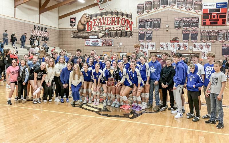 Gladwin’s volleyball team invited the fans from the stands to pose for a picture with the Cedar Cup, which the Flying G’s won last Wednesday night by sweeping a three-set match at rival Beaverton.