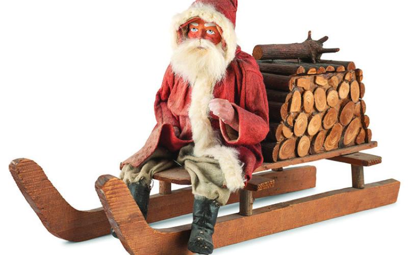 Leave it to Santa Claus to fill a bundle of firewood with candy! This papier-mache figure of Santa on a sled is a candy container. KOVELS.COM