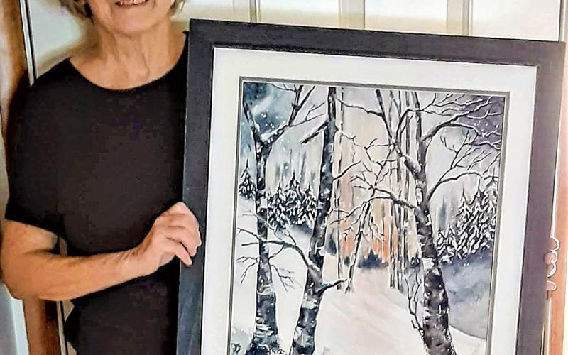Longtime Gladwin Area Artist Guild member, Dorothy Koloff, at the 2021 Fall Show holding her painting, Magic of Winter, that won the Viewer’s Choice award that year.
