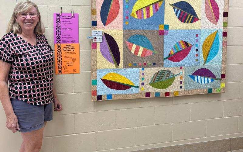 One of two beautiful quilts to be auctioned off during the show. Pictured is local artist Jan Berg-Rezmer, who made this quilt.