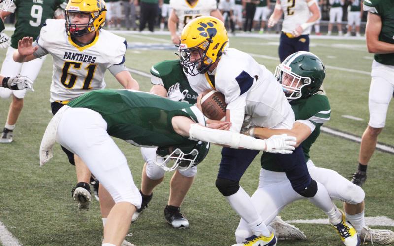Standish-Sterling quarterback Malachi Schaenzer is wrapped up by a pair of Clare tacklers during Friday night’s victory for the Pioneers.